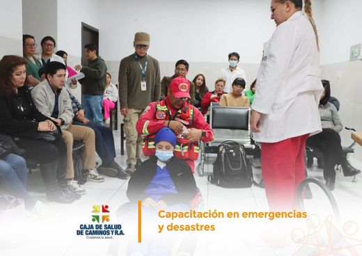 Personal de salud y bomberos durante el simulacro de evacuación de pacientes, con una silla de ruedas.